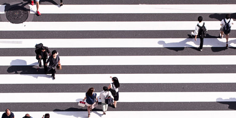 pessoas cruzando em uma faixa de pedestres recém-pintada