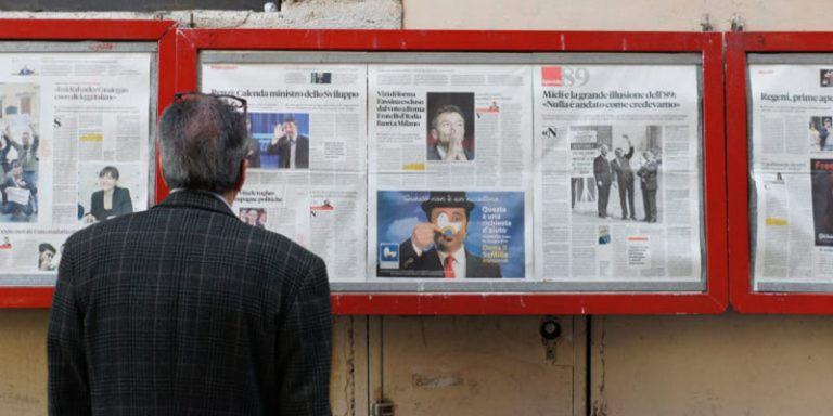 Pria melihat papan reklame surat kabar
