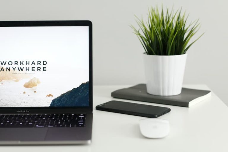 open laptop on a desk with a phone beside it and a plant Feature Image for: Why Should You Change Your Recruitment Strategy during COVID-19?