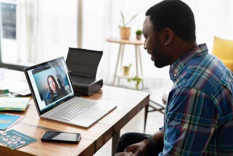 un homme sur son ordinateur portable ayant une entrevue Image vedette pour: Top 10 des meilleures pratiques d'entrevue virtuelle pour les gestionnaires d'embauche