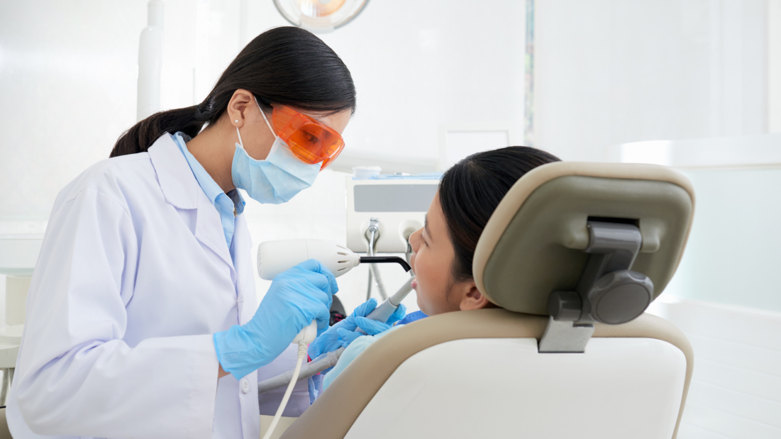 female dentist doing an operation to a female patient