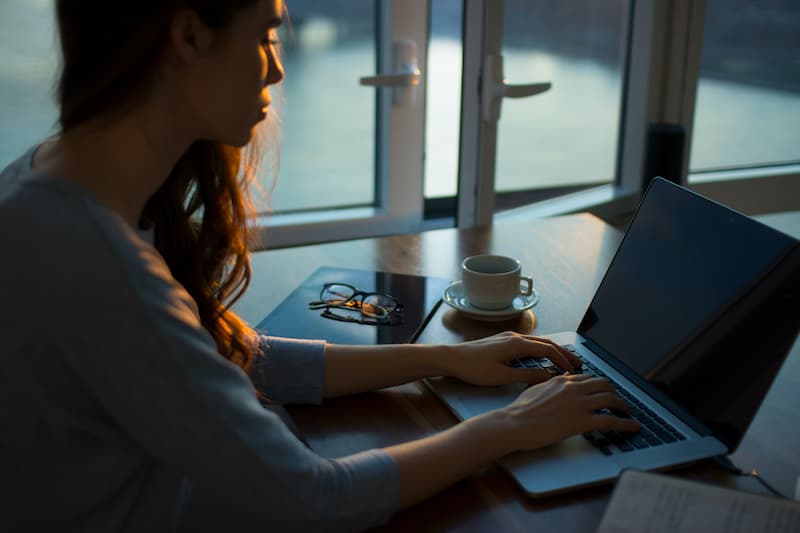 a woman sitting on her table working on her laptop Feature image for- how to get a work from home job in the UK