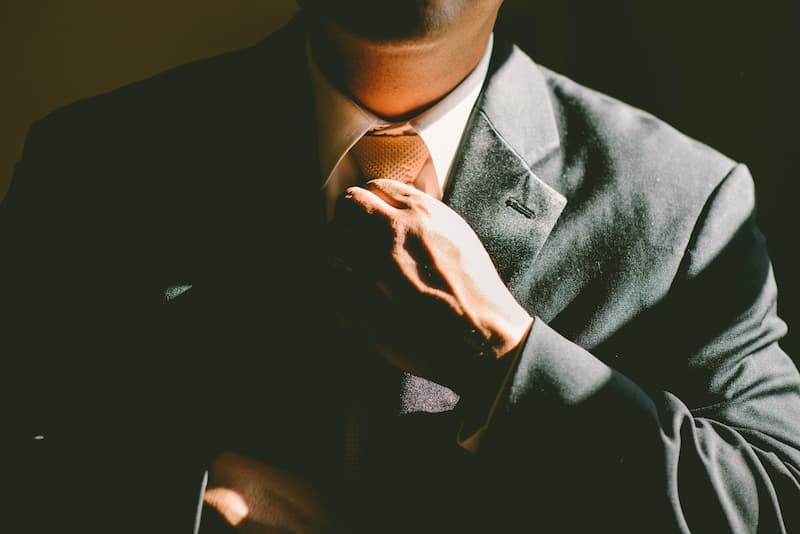 man adjusting his tie Feature Image For: ssential Guide To Overcoming After Getting Fired