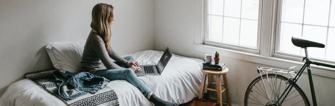 student working on her bed